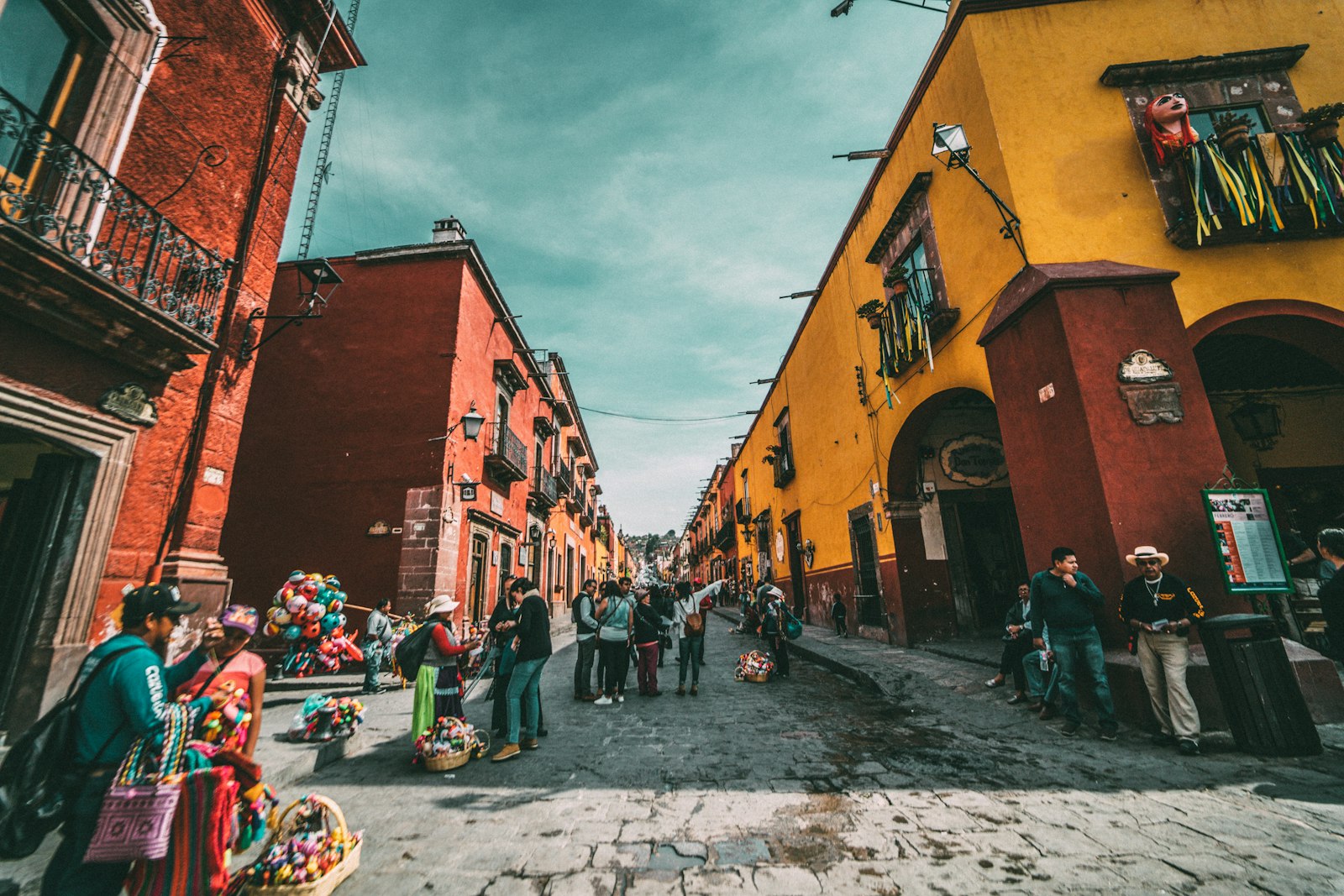 Rua colorida de San Miguel de Allende com casas vermelhas e amarelas